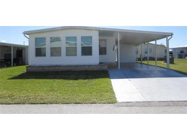 Charming single-story home featuring a covered parking area, well-maintained lawn, and traditional architecture at 705 Blackburn Blvd, North Port, FL 34287