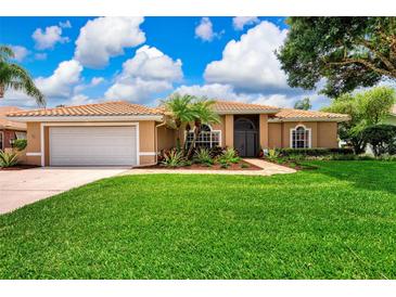 Charming home featuring a well-maintained lawn and lush tropical landscaping at 8449 Lone Eagle Way, Sarasota, FL 34241