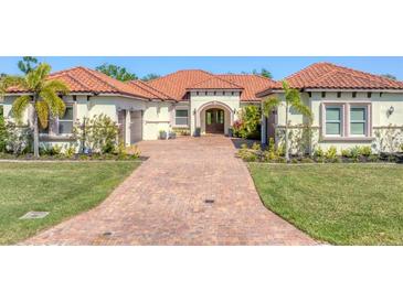 Stunning home with red tile roof, paver driveway and lush tropical landscaping at 909 143Rd Ne St, Bradenton, FL 34212