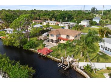 Waterfront home with a backyard featuring a dock, deck, and lush landscaping at 107 Myakka Dr, Venice, FL 34293