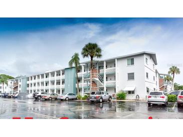 Multi-story condominium building with parking area and palm trees at 1815 Restful Dr # N-27, Bradenton, FL 34207
