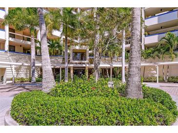 Condominium building exterior featuring lush tropical landscaping and architecture at 2020 Harbourside Dr # 454, Longboat Key, FL 34228