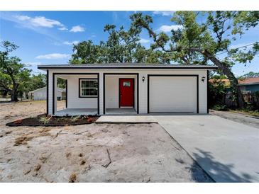 Charming single-story home boasts a bright red front door and an attached one car garage at 732 15Th E St, Bradenton, FL 34208