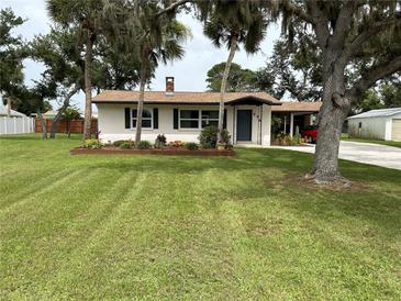 Charming single-story home with lush lawn and mature trees, inviting curb appeal at 775 Liberty St, Englewood, FL 34223