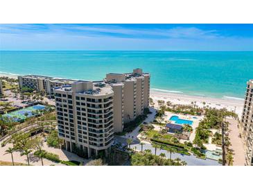 Stunning aerial view of a beachfront condominium complex with a pool and private beach access at 1211 Gulf Of Mexico Dr # 309, Longboat Key, FL 34228