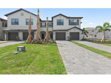Inviting townhome boasts a well-manicured lawn, long driveway, and an attached garage at 14783 Lyla Ter, Bradenton, FL 34211