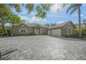 Charming home featuring a paved driveway, lush landscaping, and a welcoming entryway at 1693 Landings Ln, Sarasota, FL 34231