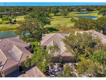 Stunning aerial view of a tile-roofed home overlooking a lush golf course and serene lake at 3320 Hadfield Greene # 39, Sarasota, FL 34235