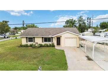 Charming single story home with a tan exterior, well-maintained lawn, and a carport for covered parking at 4221 3Rd W Ave, Palmetto, FL 34221