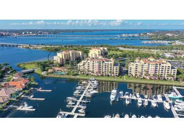 Panoramic aerial view of waterfront condo community with private marina, lush landscaping, and coastal access at 611 Riviera Dunes Way # 107, Palmetto, FL 34221