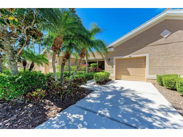 Charming single-story home featuring a beige facade, well-manicured landscaping, and a two-car garage at 9121 Stone Harbour Loop, Bradenton, FL 34212