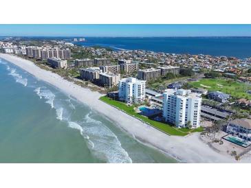 Gorgeous aerial view of beachfront condos with a beautiful white sand beach, turquoise ocean water, and lush green landscaping at 1000 Longboat Club Rd # 604, Longboat Key, FL 34228