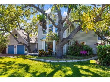 Beautiful home exterior with lush greenery, mature trees, and a spacious lawn, showcasing a serene outdoor setting at 1434 Ladue Ln, Sarasota, FL 34231