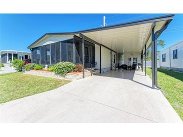 Well-maintained home with a covered carport, a screened-in porch, and manicured landscaping at 216 Palm Air Dr, Osprey, FL 34229