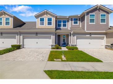 Inviting two-story townhome featuring an attached garage, well-maintained lawn, and a charming front entrance at 3644 Pitch Ln, Sarasota, FL 34232
