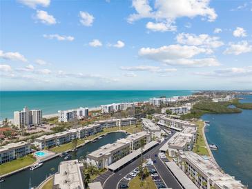 Stunning aerial view of a coastal community with water access, beaches, and manicured landscaping at 4390 Exeter Dr # 206, Longboat Key, FL 34228