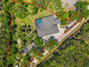 Stunning aerial view of the expansive property with a sparkling pool surrounded by lush landscaping and a well-defined perimeter at 5442 Kent Rd, Venice, FL 34293