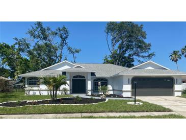 Charming single-story home with a well-manicured lawn and dark gray garage door at 5810 42Nd E St, Bradenton, FL 34203