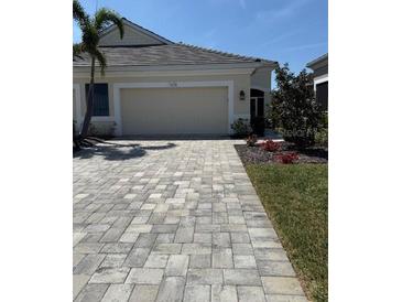 Charming one-story home featuring a two-car garage, manicured lawn, and inviting curb appeal at 7608 Registrar Way, Sarasota, FL 34243