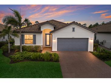 Beautiful home with a two-car garage, a tile roof, nice landscaping, and attractive exterior paint at 20892 Cattail Blvd, Venice, FL 34292