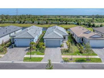 New construction homes showing the community's appealing landscaping, brick-paved driveways, and serene water view at 6260 Fish Eagle Ct, Nokomis, FL 34275