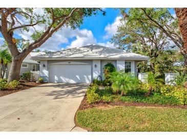 Charming single-story home with well-manicured landscaping, a driveway, and a two-car garage at 667 Crossfield Cir # 1, Venice, FL 34293