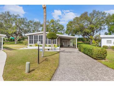 Charming home featuring a long drive and landscaped front yard, complemented by mature trees and a screened-in porch at 8517 Buckingham Pl, Palmetto, FL 34221