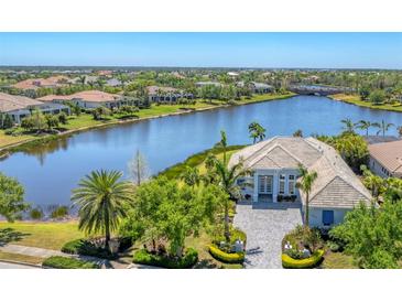 Stunning waterfront home boasts lush landscaping and a beautiful facade at 16436 Daysailor Trl, Lakewood Ranch, FL 34202