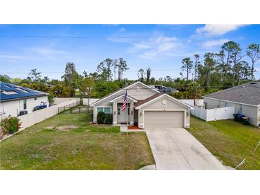Inviting single-story home with a well-manicured lawn, fenced in yard, and a spacious driveway at 2302 Manheim Ave, North Port, FL 34286