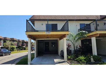 Inviting two-story condo features a covered parking area and quaint landscaping at 3390 Ramblewood Ct, Sarasota, FL 34237