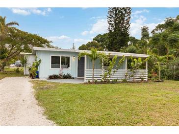 Charming home with light blue siding, white trim, covered porch, and a well-maintained front yard at 4111 Rockefeller Ave, Sarasota, FL 34231