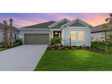 Charming single-story home boasting a well-manicured lawn, two-car garage, and inviting curb appeal at sunset at 4240 Pond Brook Ct, Bradenton, FL 34211