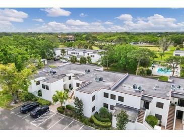 An aerial view of a multi-unit residential building featuring lush landscaping and a refreshing community pool at 5042 Marsh Field Rd # 16, Sarasota, FL 34235
