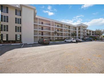 Residential condo building exterior with ample parking and manicured lawn at 7461 W Country Club N Dr # 207, Sarasota, FL 34243