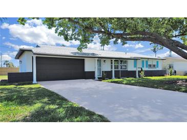 Charming single-story home with a well-manicured lawn and two-car garage at 7797 Barry Ct, Seminole, FL 33772
