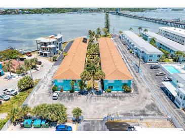 Aerial view of coastal apartments with bridge in background, ample parking, and tidy landscaping at 117 7Th N St # 14, Bradenton Beach, FL 34217