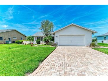 Charming home featuring a well-manicured lawn, brick driveway, and a two-car garage at 1906 70Th W St, Bradenton, FL 34209