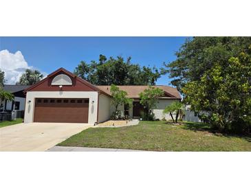 Charming single-story home with a well-manicured lawn, mature trees, and a two-car garage at 2385 Tall Oak Ct, Sarasota, FL 34232