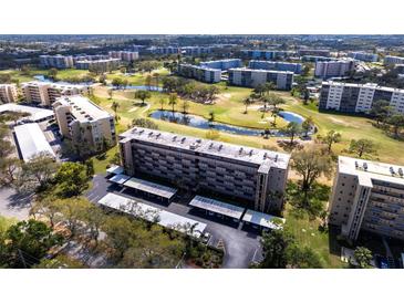 Stunning aerial view of the condo building overlooking a lush golf course with ponds and mature trees at 3620 Ironwood Cir # 606, Bradenton, FL 34209
