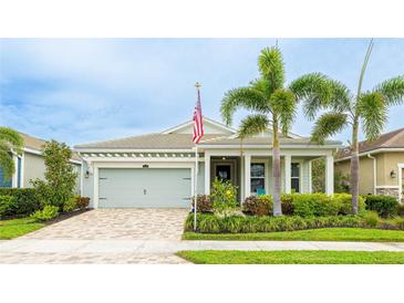 Charming single-story home featuring a two-car garage, well-manicured landscaping, and inviting front porch at 5416 Hope Sound Cir, Sarasota, FL 34238