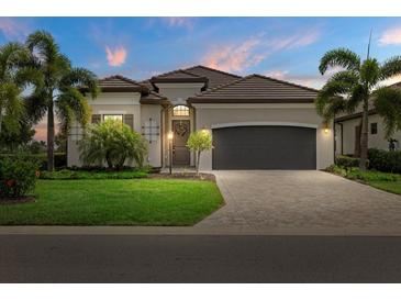 Charming single-story home with a tile roof, a lush lawn, and elegant landscaping with palm trees in a well-maintained community at 5811 Brandon Run, Bradenton, FL 34211