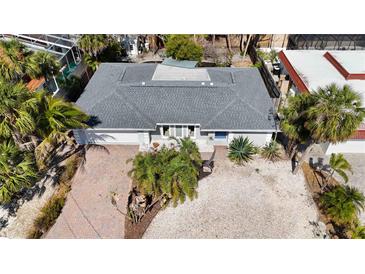 An aerial view of a single-story home featuring a new gray roof and tropical landscaping with palm trees at 711 Birdsong Ln, Sarasota, FL 34242