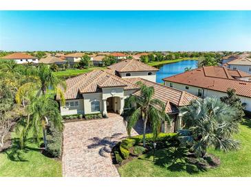 Elegant home featuring a tile roof, paver driveway, lush landscaping and waterfront views in a vibrant community at 13107 Bridgeport Xing, Lakewood Ranch, FL 34211