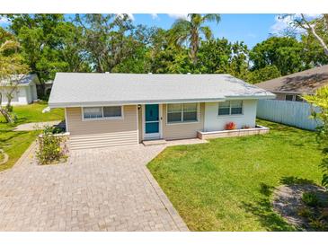 Charming single-story home with a manicured lawn, brick paver walkway, and vibrant blue front door at 2225 Alice Rd, Sarasota, FL 34231