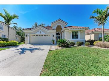 Charming single-story home featuring a well-manicured lawn, tropical landscaping and a tile roof at 322 Langholm Dr, Venice, FL 34293