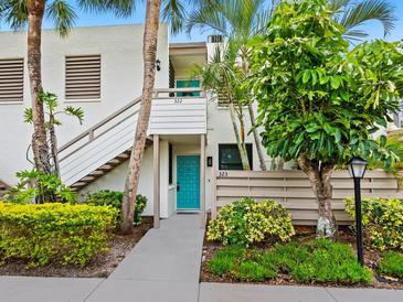 Inviting condo exterior with tropical landscaping and a bright blue front door creating a welcoming entrance at 323 Timberlake Dr # 323, Bradenton, FL 34210