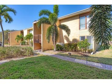 Attractive condo exterior featuring palm trees, lawn, and stucco facade in a tropical setting at 3457 Clark Rd # 156, Sarasota, FL 34231