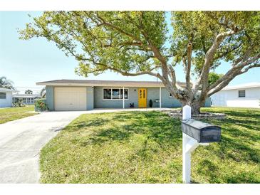 Charming single-story home with a well-maintained lawn and a vibrant yellow front door at 568 Sheridan Dr, Venice, FL 34293