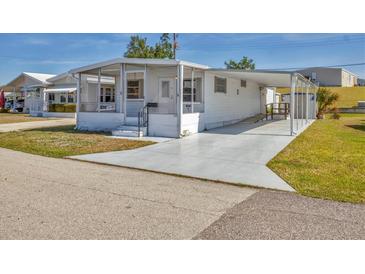 Charming single-story home featuring a screened front porch and covered carport on a sunny day at 1212 41St Avenue E Dr, Ellenton, FL 34222