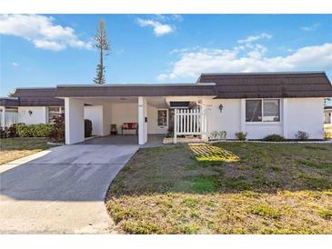 Charming single story home with a carport and well maintained front yard on a sunny day at 3917 Ashwood Ln # 57, Sarasota, FL 34232